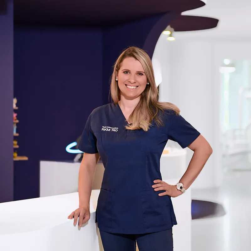 Darja Meinert – Dentalhygienikerin im RKM 740 Zahnmedizin Düsseldorf Darja Meinert, Dentalhygienikerin im RKM 740 Zahnmedizin Düsseldorf, im Empfangsbereich der Praxis