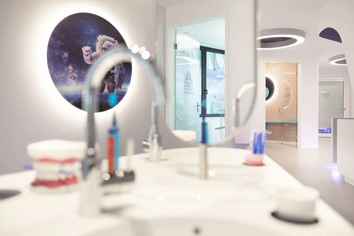Waschplatz mit Astronaut – Kinderzahnheilkunde MiLiNo RKM 740 Düsseldorf Waschplatz der Kinderzahnheilkunde MiLiNo im RKM 740 Düsseldorf mit Astronautenmotiv und Blick in den Behandlungsraum