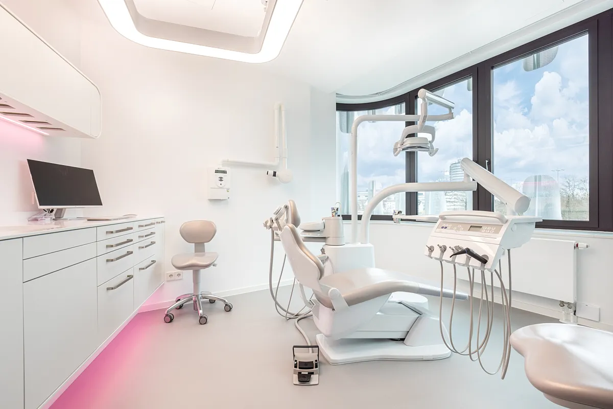 Behandlungsraum – RKM 740 Zahnmedizin Düsseldorf Helles Behandlungszimmer der RKM 740 Zahnmedizin in Düsseldorf mit modernem Lichtdesign und Stadtblick