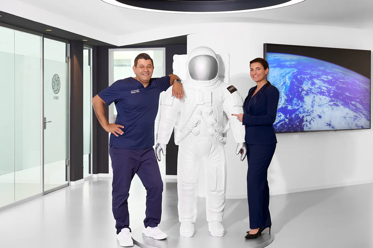 Dr. med. dent. Michael Alte und Mary Alte – RKM 740 Zahnmedizin Düsseldorf Dr. med. dent. Michael Alte und Mary Alte im RKM 740 Zahnmedizin Düsseldorf vor Astronautenfigur